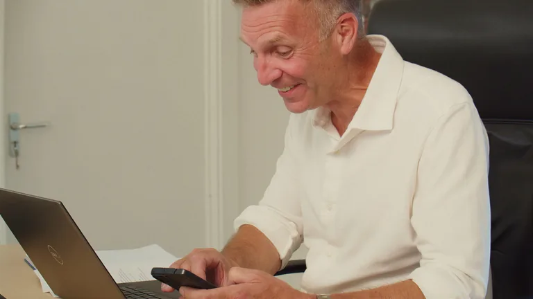 Smiling while working at a laptop in the office