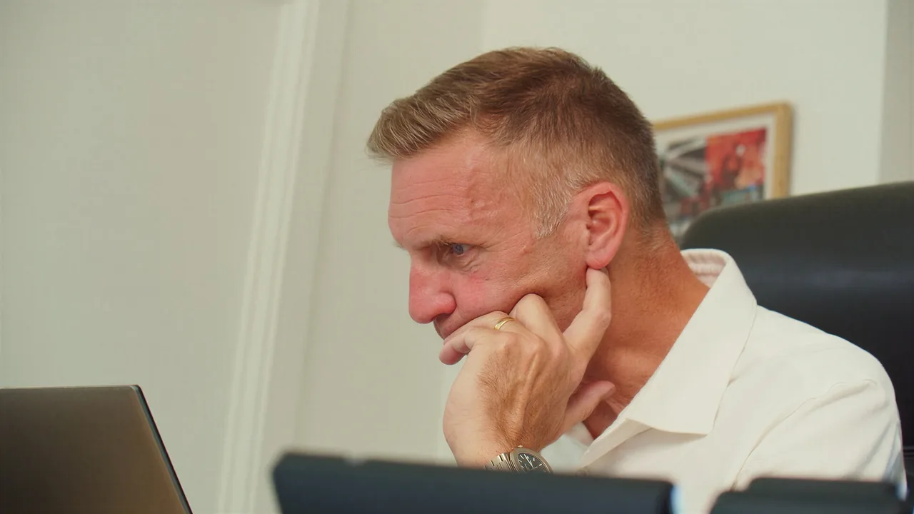 Deep in thought at a desk in the Stratworth Advisory office