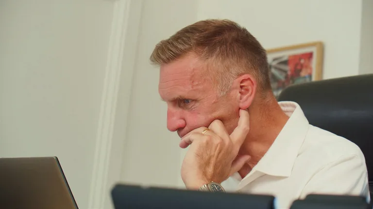 Deep in thought at a desk in the Stratworth Advisory office