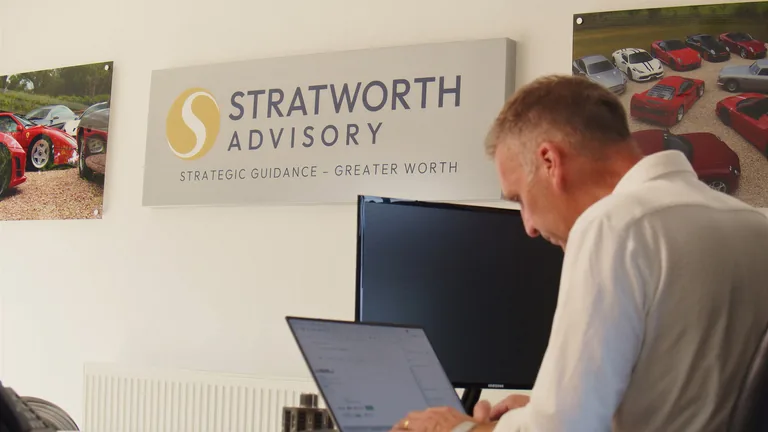 At work beneath the Stratworth Advisory sign in the office