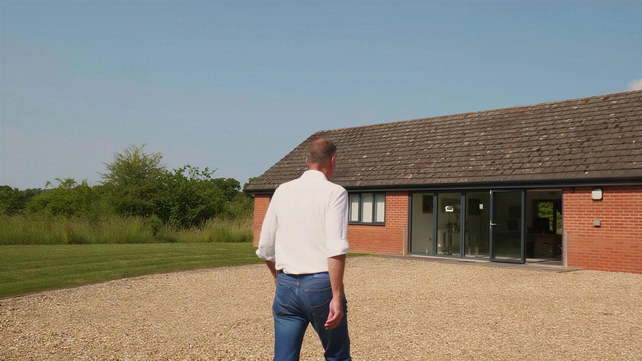 Walking across a gravel drive towards a single-storey brick office